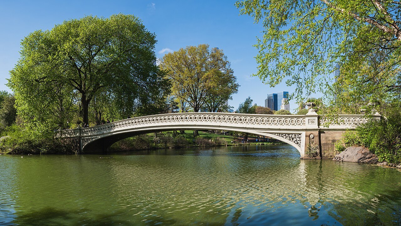 Bow Bridge crossing the Lake in spring, with Central Park West beyond