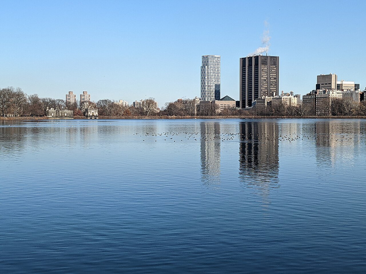 The Reservoir in still water, with the East Side's towers reflected in it