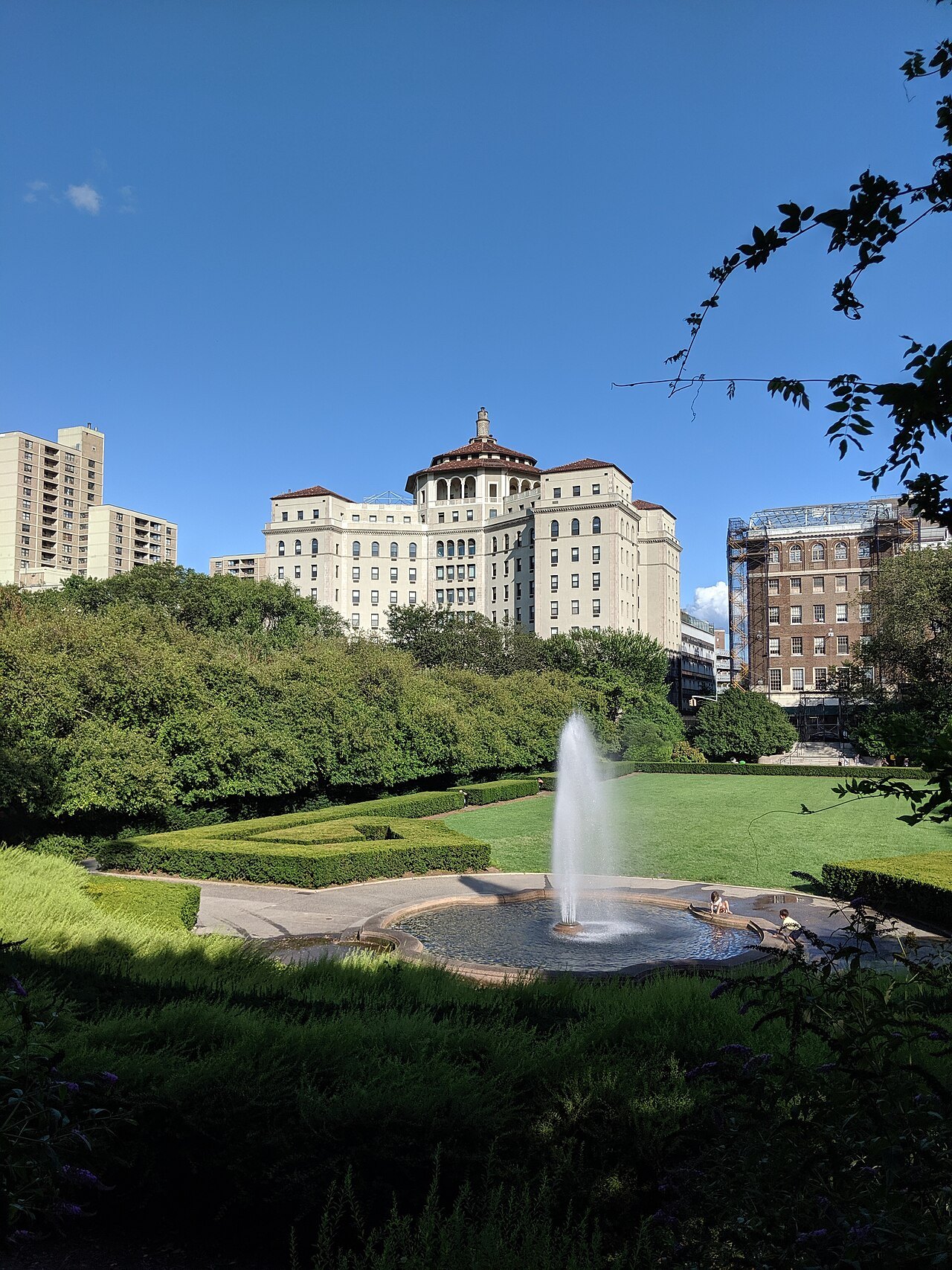 The fountain and clipped lawns of the Conservatory Garden, with Fifth Avenue beyond