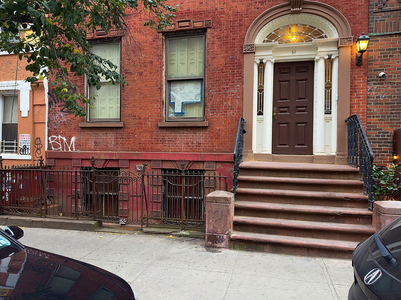 An old brick house with a fanlight doorway and stoop on Market Street