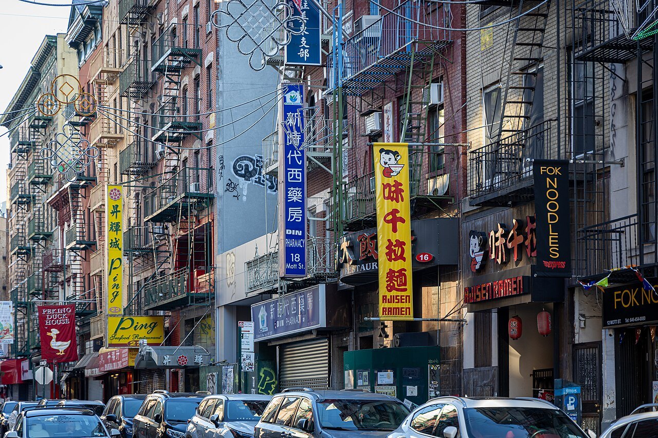 Signs stacked up the fire-escaped tenements of Mott Street