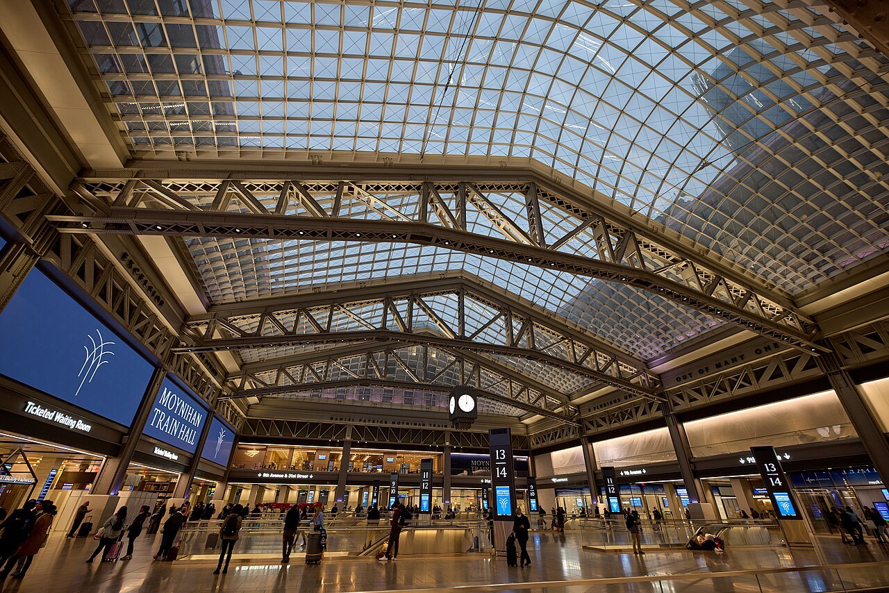 Travelers under the skylit roof of Moynihan Train Hall