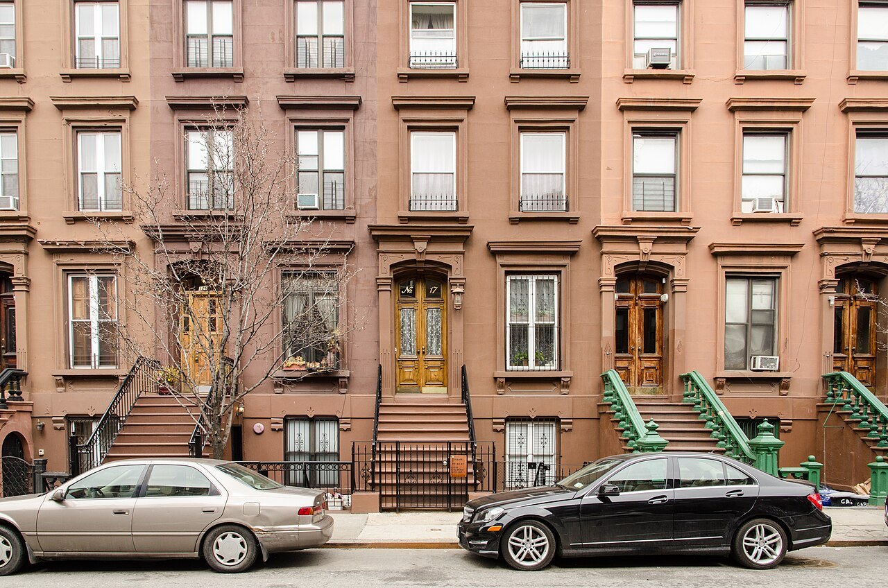 A row of brownstones with high stoops on East 126th Street in Harlem