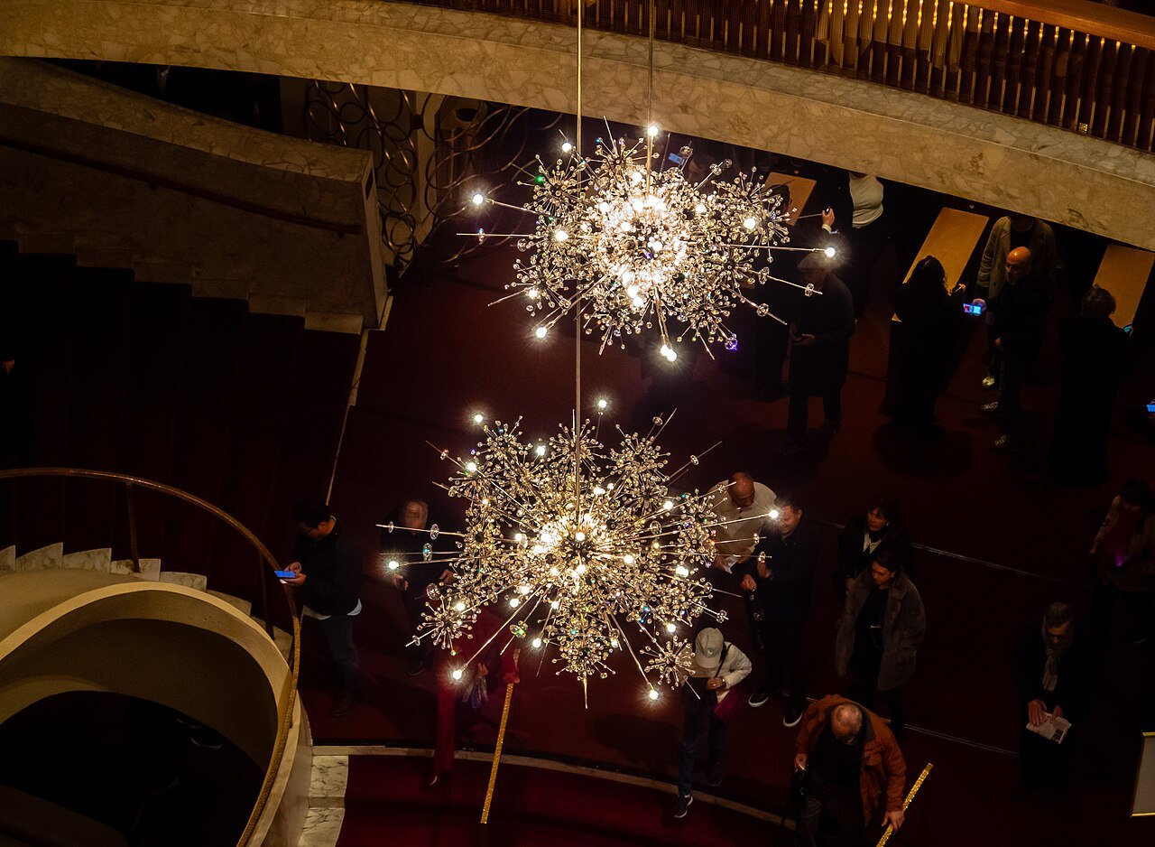 The starburst chandeliers above the curving staircases of the Metropolitan Opera House lobby