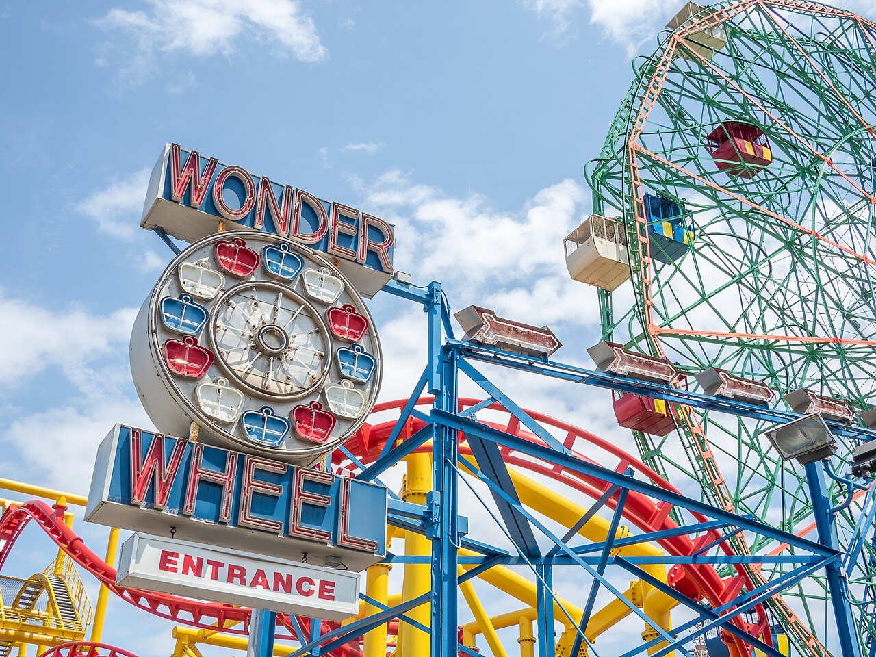 The Wonder Wheel's sign and the rides at Coney Island