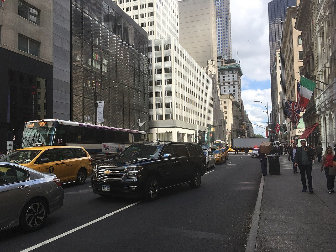 Fifth Avenue looking north from 51st Street, with taxis and a bus