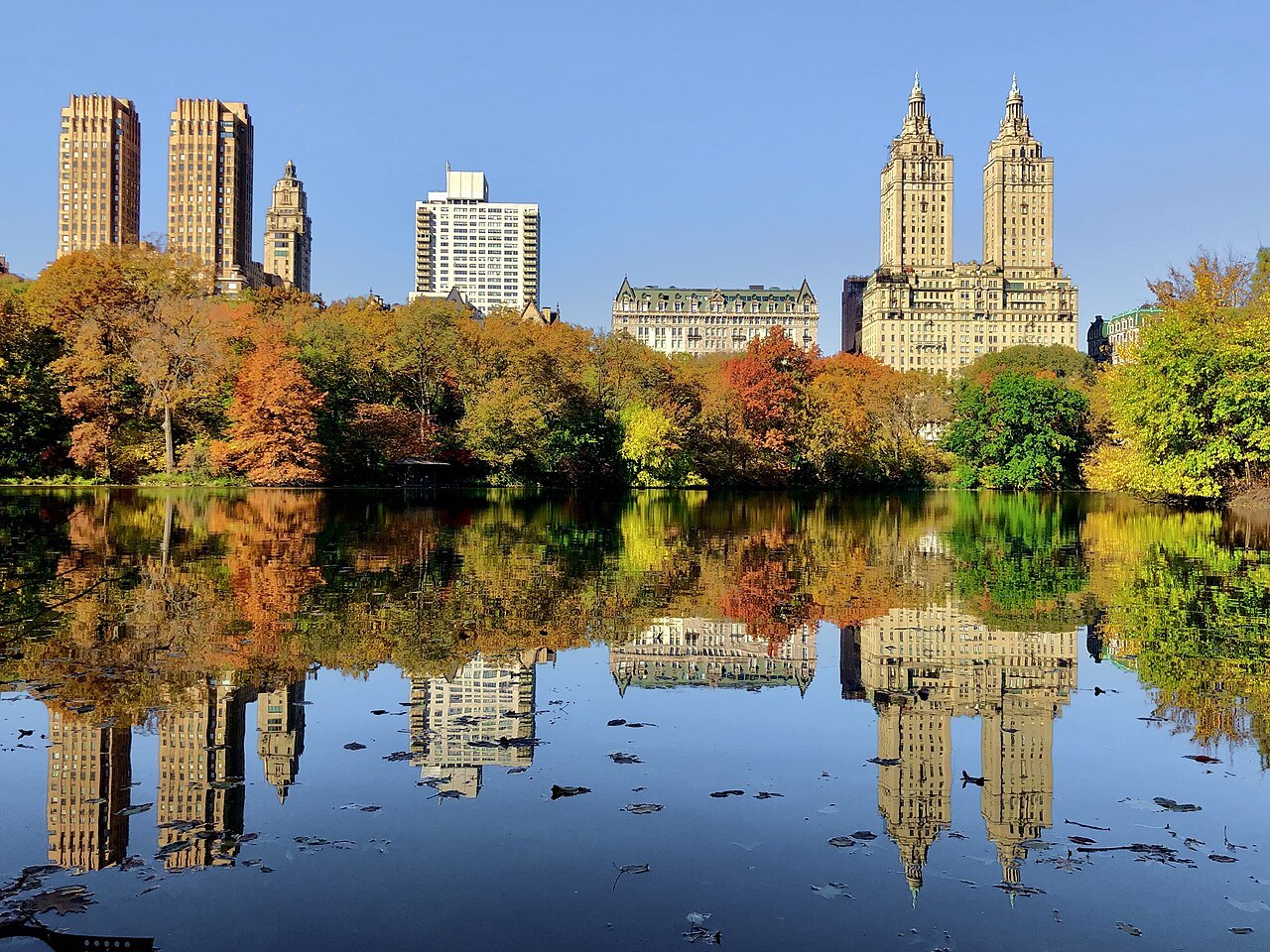 The Lake in full autumn color, the towers of Central Park West reflected in it