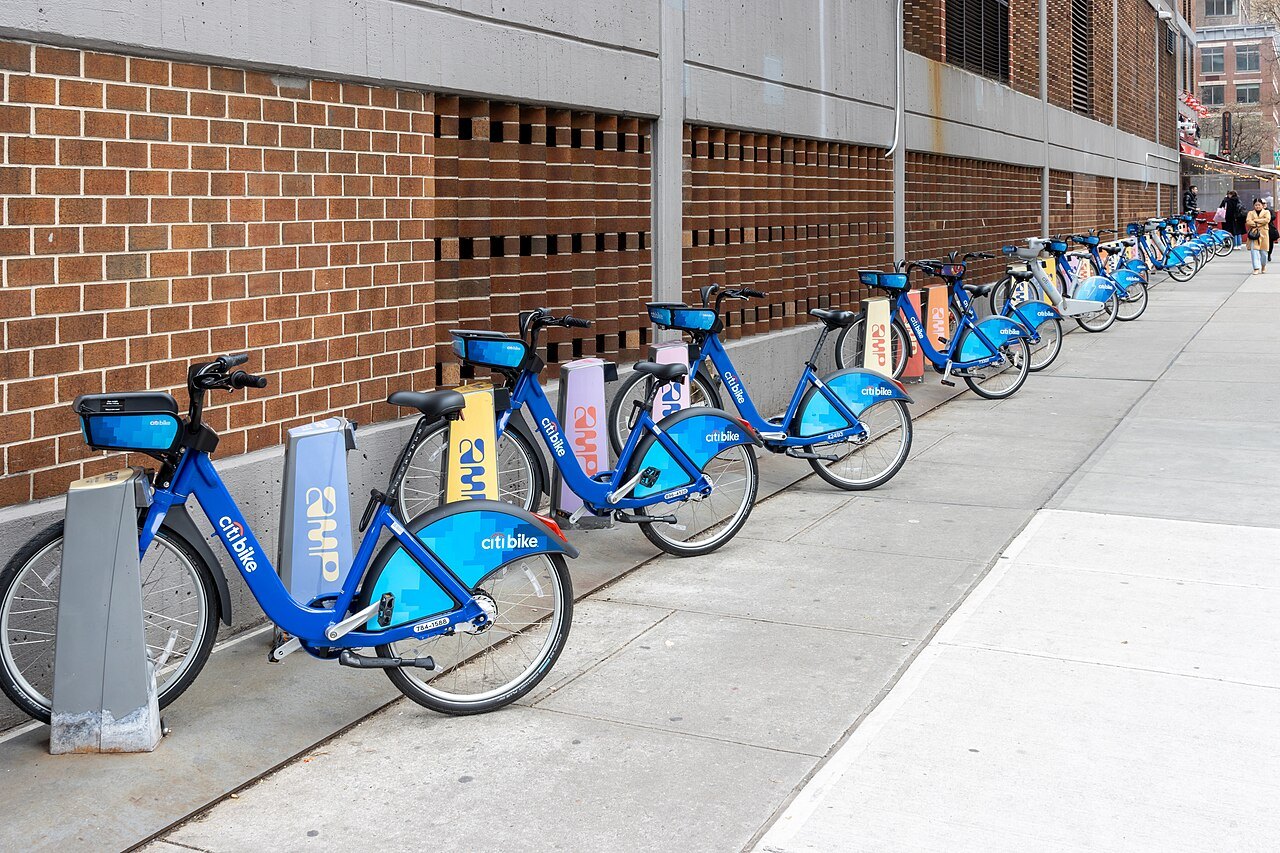 A row of Citi Bikes docked along a Manhattan sidewalk