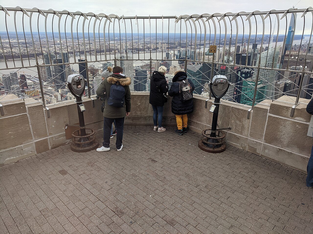 Visitors at the railings of the Empire State Building's open-air terrace