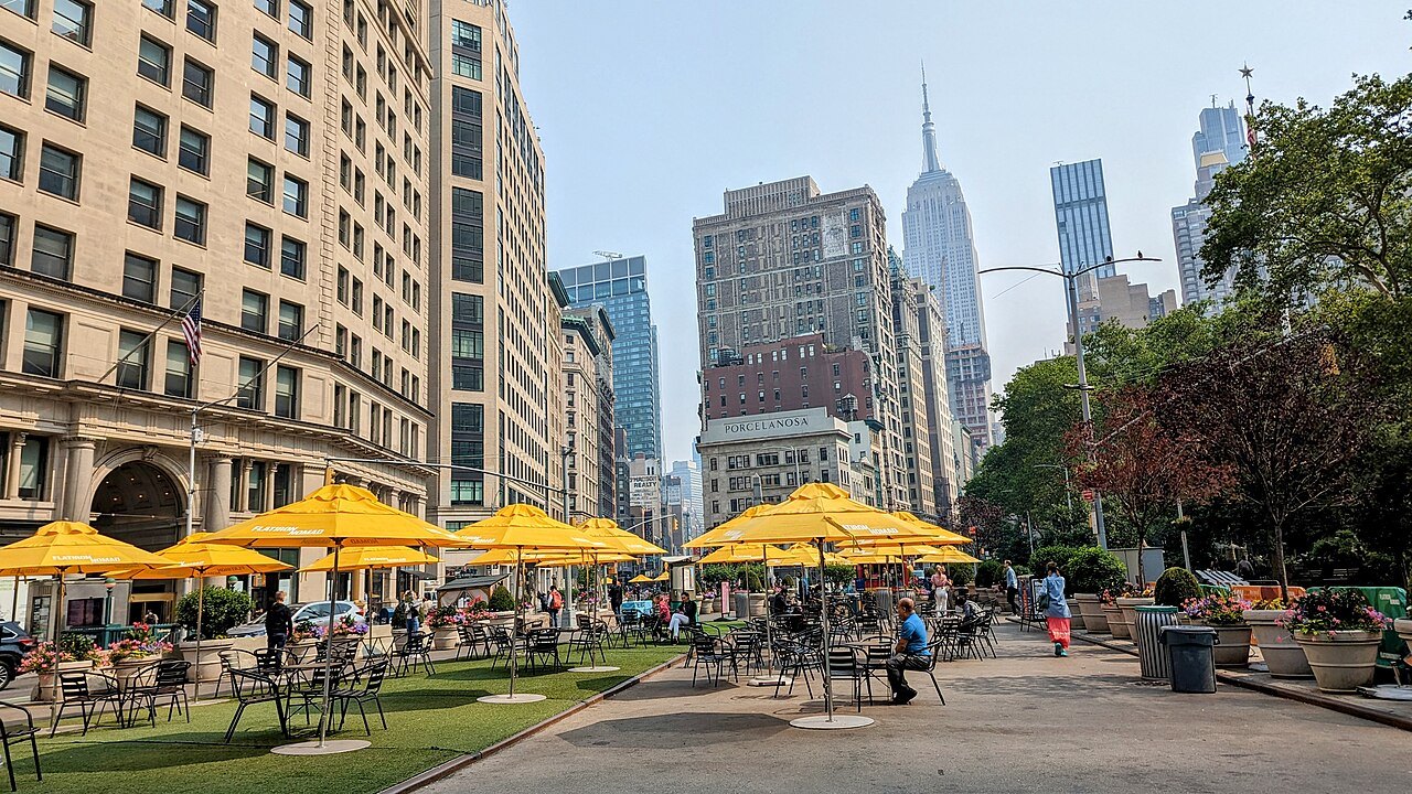 The yellow umbrellas of the Flatiron plaza, the Empire State Building beyond