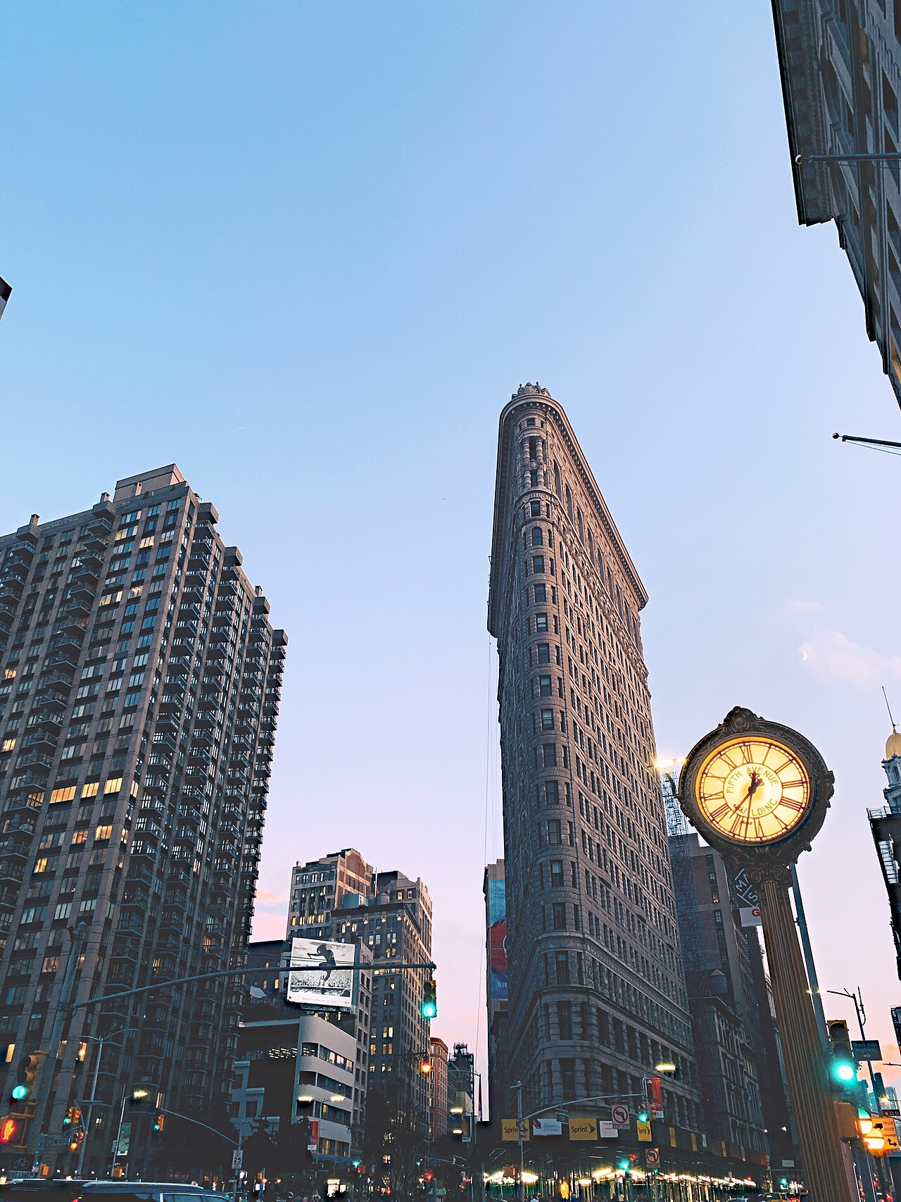 The Flatiron Building and the sidewalk clock in the evening