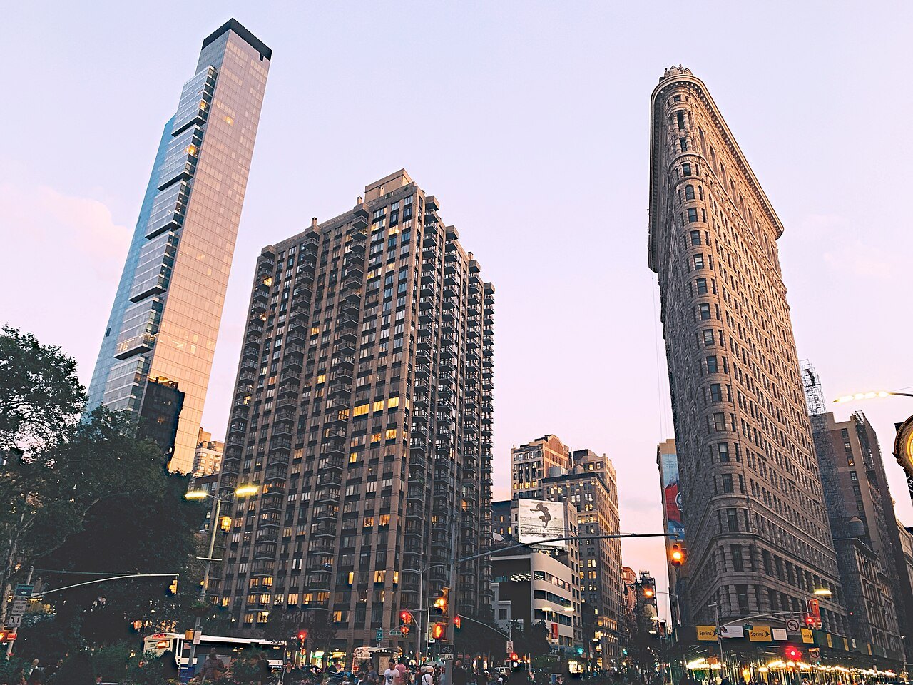The Flatiron Building's narrow prow at dusk, among newer towers