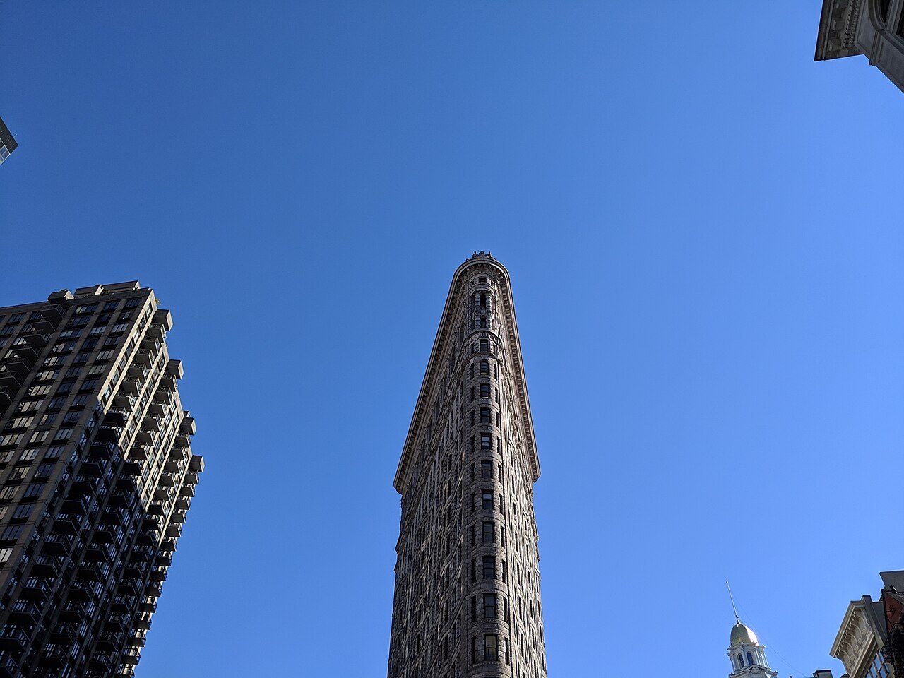The prow of the Flatiron Building against a clear blue sky