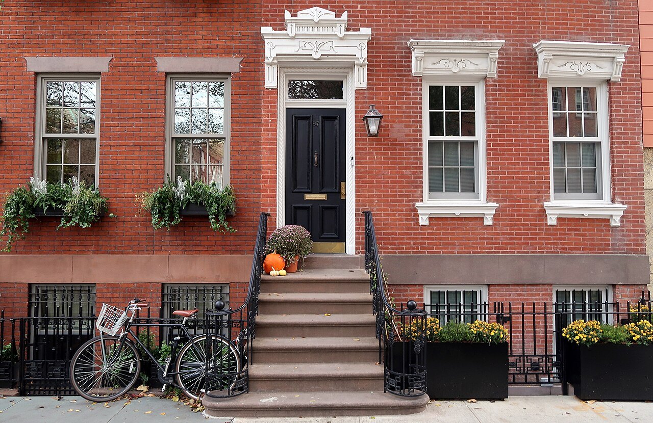 A brick house of 1899 on Barrow Street, with its stoop and window boxes