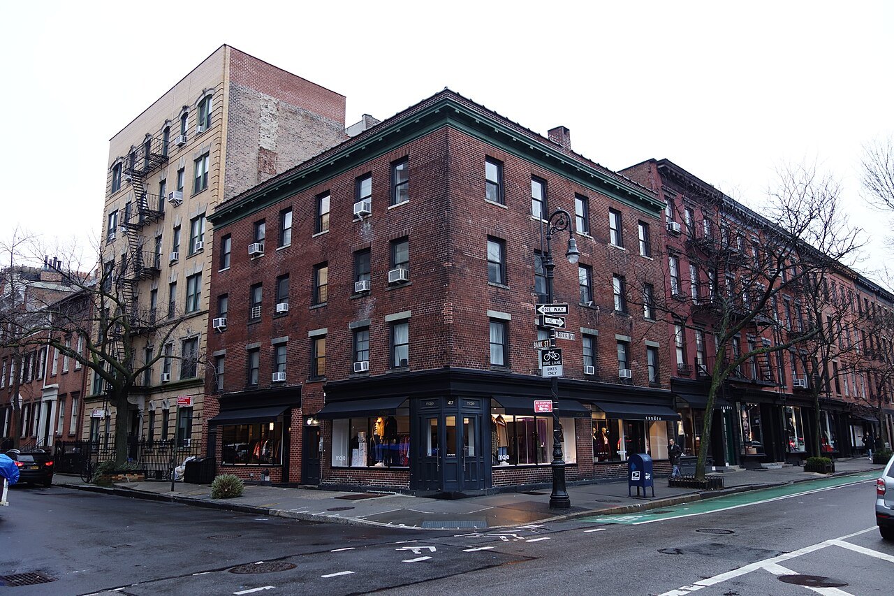 A red-brick corner building on Bleecker Street in the Village