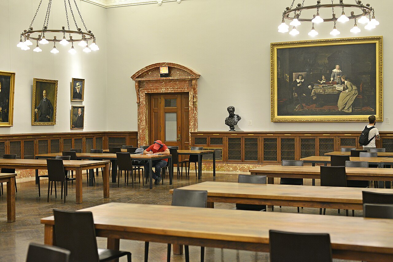 A reading room inside the library, with paintings and busts on its walls