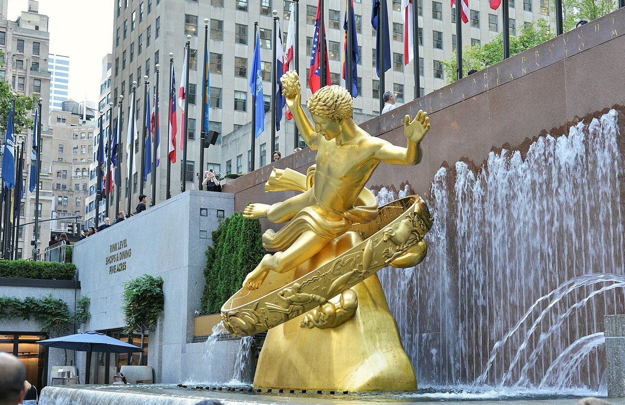 The gilded Prometheus beside the plaza's fountain wall