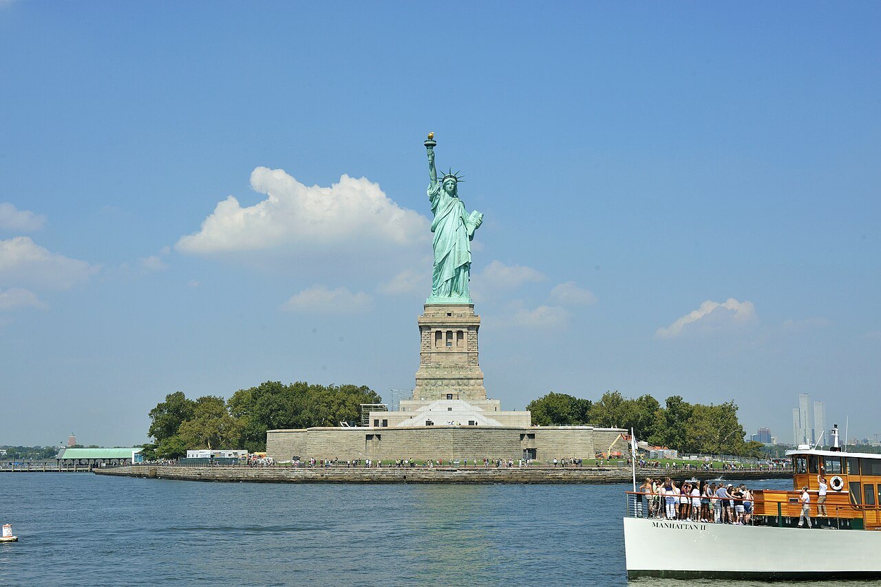 The Statue of Liberty on Liberty Island, a ferry at the landing