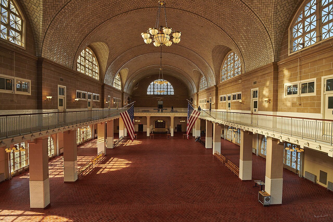 The vaulted Registry Room on Ellis Island, its flags hanging from the gallery