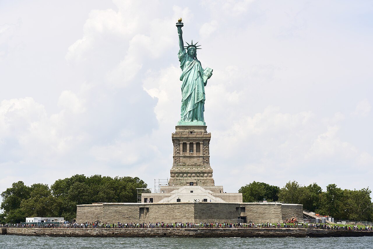 The Statue of Liberty and its pedestal on a bright cloudy day