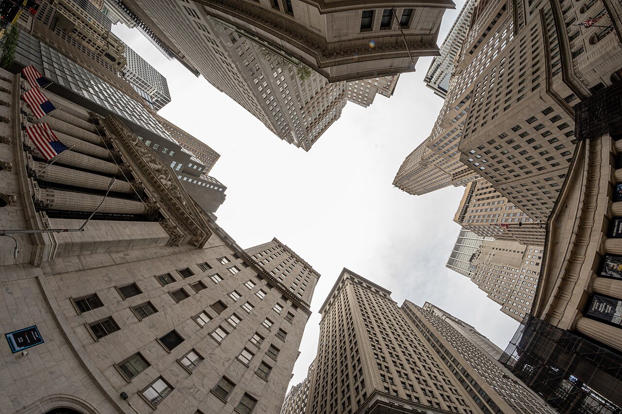 Looking straight up between the towers of Wall Street